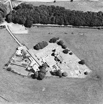 Oblique aerial view centred on the remains of the abbey and abbot¿s house, taken from the WSW.