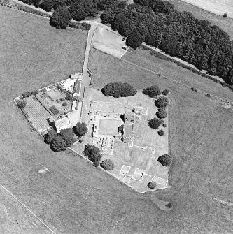 Oblique aerial view centred on the remains of the abbey and abbot¿s house, taken from the SW.