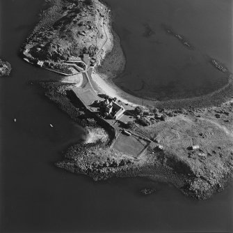 Oblique aerial view centred on the abbey with coast batteries adjacent, taken from the NW.