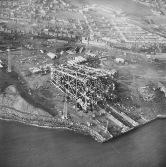 Aerial view from South West of oil platform jacket under construction, and Denbeath, Methil.