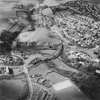 Oblique aerial view of Leslie centred on the village housing development designed by Wheeler and Sproson in 1952-56 with a railway viaduct adjacent, and recorded as part of the Wheeler and Sproson Project.  Taken from the E.