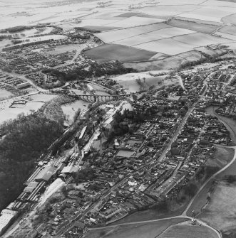 Oblique aerial view of Leslie centred on the village housing development designed by Wheeler and Sproson in 1952-56 with a railway viaduct adjacent, and recorded as part of the Wheeler and Sproson Project.  Taken from the NE.