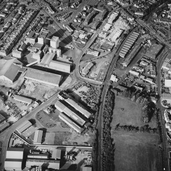 Oblique aerial view centred on the whisky distillery with the engineering works and works adjacent, taken from the WSW.