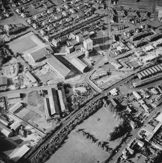 Oblique aerial view centred on the whisky distillery with the engineering works and works adjacent, taken from the SSW.