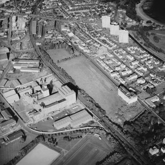 Oblique aerial view centred on the site of the works with the engineering works, houses, foundry and offices and works adjacent, taken from the W.