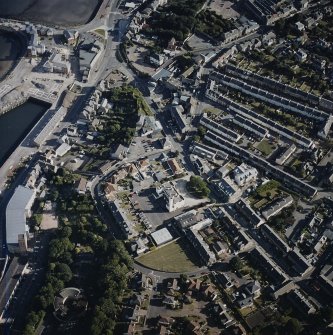 Oblique aerial view centred on the fire station with the works and college adjacent, taken from the N.