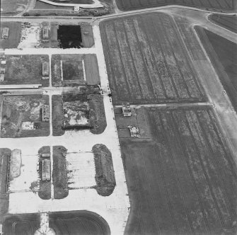 Oblique aerial view of Crail Airfield centred on the remains of the control tower, buildings, huts and aircraft hangars, taken from the WSW.