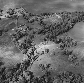 Oblique aerial view of Mountquhanie house, centred on the country house, 'dovecot', stables,  farmsteading and the remains of a castle, taken from the S.