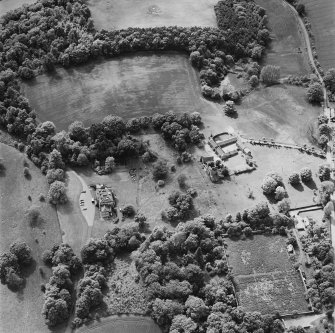 Oblique aerial view of Mountquhanie House centred on the country house, 'dovecot', stables and the remains of a castle, taken from the ENE.