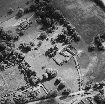 Oblique aerial view of Mountquhanie House centred on the country house, 'dovecot', stables and the remains of a castle, taken from the NNE.
