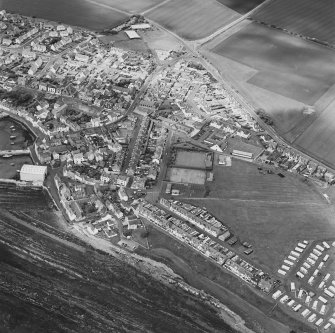 Oblique aerial view of St Monance centred on the village and harbour, taken from the ESE.