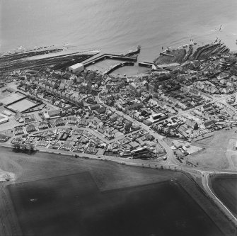 Oblique aerial view of St Monance centred on the village and harbour, taken from the NNW.