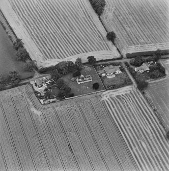 Oblique aerial view centred on the remains of the church and burial ground, taken from the SSW.