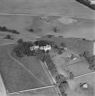 Oblique aerial view centred on Pitcullo castle with dovecot adjacent, taken from the SSE.