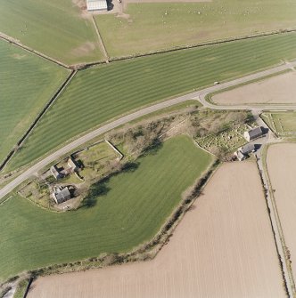 Oblique aerial view centred on the farmsteading, manse and walled garden, with the church, churchyard and war memorial adjacent, taken from the SSW.