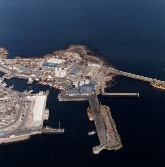 Oblique aerial view centred on the harbours, town house, tollbooth and lifting bridge, taken from the SW.