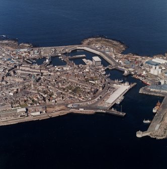Oblique aerial view centred on the harbours, town house, tollbooth and lifting bridge, taken from the SW.
