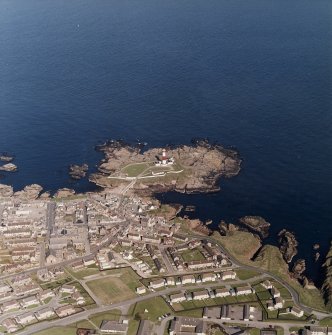 Oblique aerial view centred on the lighthouse with the school and churches adjacent, taken from the W.