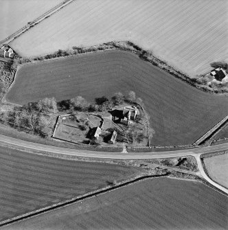 Oblique aerial view centred on the farmsteading, manse and walled garden, taken from the NW.