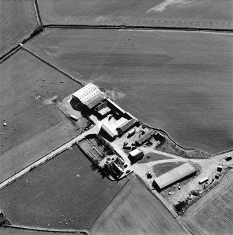 Oblique aerial view centred on the farmhouse and farmsteading, taken from the NE.