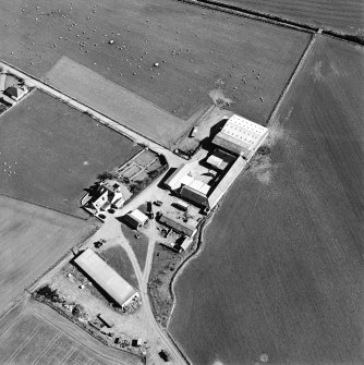 Oblique aerial view centred on the farmhouse and farmsteading, taken from the NW.