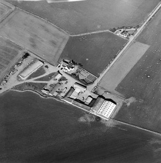 Oblique aerial view centred on the farmhouse and farmsteading, taken from the SW.