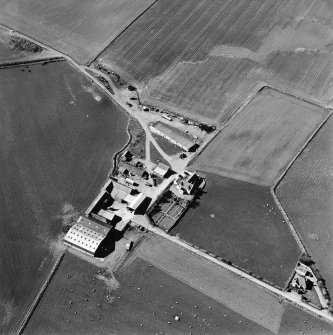 Oblique aerial view centred on the farmhouse and farmsteading, taken from the SE.