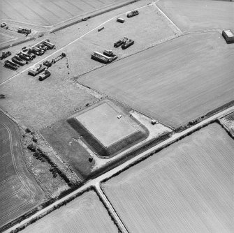 Oblique aerial view centred on the remains of the radar station, pillboxes, building and reservoir, taken from the NE.