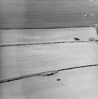 Oblique aerial view centred on remains of the pillbox, bunker and building, taken from the SE.