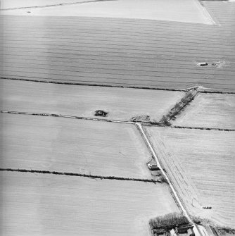 Oblique aerial view centred on remains of the pillbox, bunker and building, taken from the ESE.