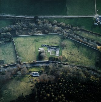 Oblique aerial view centred on the remains of the abbey with the walled garden and house adjacent, taken from the N.