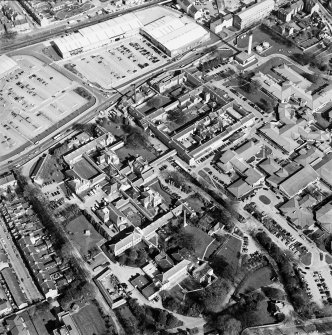 Oblique aerial view centred on the hospital, obelisk, factory and mill, taken from the W.