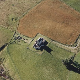 Oblique aerial view of Corgarff castle centred on the tower-house with the remains of a pond, farmstead and the cropmarks of a building adjacent, taken from the E.