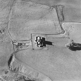 Oblique aerial view of Corgarff castle centred on the tower-house with the remains of a pond, quarry, farmstead, building and the cropmarks of a building adjacent, taken from the ESE.