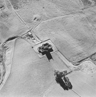 Oblique aerial view of Corgarff castle centred on the tower-house with the remains of a pond, quarry, farmstead, buildings and the cropmarks of a building adjacent, taken from the NE.