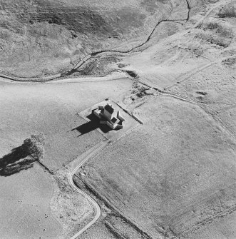 Oblique aerial view of Corgarff castle centred on the tower-house with the remains of a pond, quarry, farmstead and the cropmarks of a building adjacent, taken from the NNW.