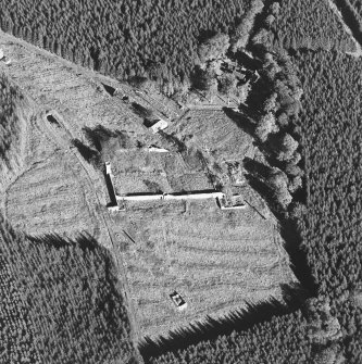 Oblique aerial view of Auchernoch centred on the remains of a country house and its grounds including a mill building, taken from the WSW.