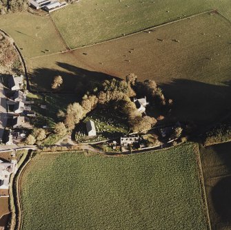 Oblique aerial view of Leslie Parish Church centred on the church and burial ground with manse, farmstead and road bridge adjacent, taken from the W.