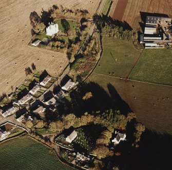 Oblique aerial view of Leslie Castle centred on the castle with church, burial ground, road bridge, manse, farmstead and farmhouse adjecent, taken from the SW.