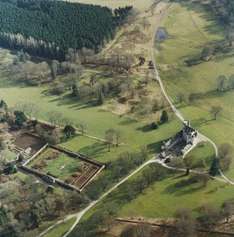 Oblique aerial view of the tower-house with walled garden adjacent, taken from the NW.