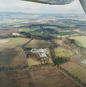 General oblique aerial view of the tower-house and its policies with Bennachie in the background, taken from the S.