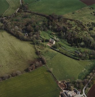 Oblique aerial view centred on the castle, garden, walls and cottage with the burial-ground adjacent, taken from the WNW.
