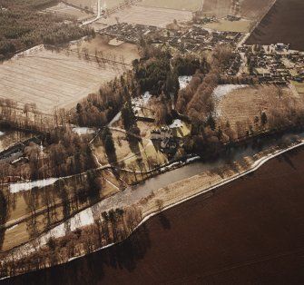 Oblique aerial view centred on the tower-house and country house with village adjacent, taken from the ENE.