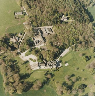 Oblique aerial view centred on the country house and farmsteading, taken from the SSW.