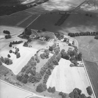 Oblique aerial view from South East of Gordon Castle estate (after demolitions), including house, tower, farm, laundry cottages and cropmarks