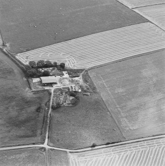 Oblique aerial view of Blervie Castle centred on the remains of a castle or tower-house with attached and adjacent farm buildings, taken from the NNW.