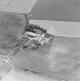 Oblique aerial view of Blervie Castle centred on the remains of a castle or tower-house with attached and adjacent farm buildings, taken from the WNW.