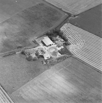 Oblique aerial view of Blervie Castle centred on the remains of a castle or tower-house with attached and adjacent farm buildings, taken from the WSW.
