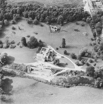 Oblique aerial view centred on the country house during renovation and the remains of the laundry, taken from the E.