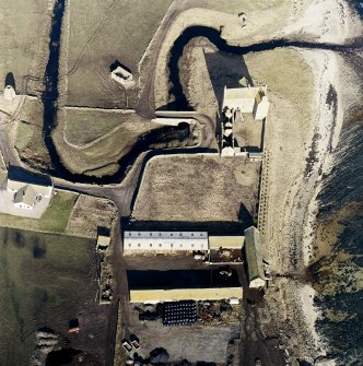 Oblique aerial view of the castle, bridge, farmsteading and the remains of the mausoleum, dovecot and anti-tank blocks, taken from the SE.
